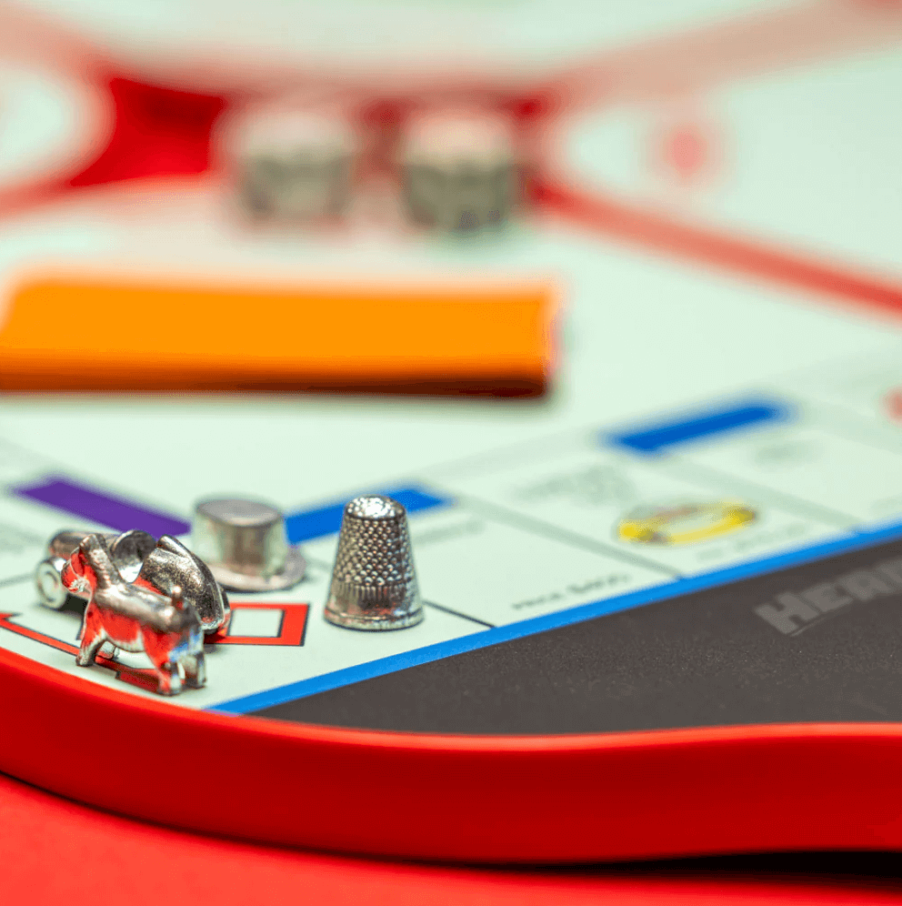 Monopoly game pieces on pickleball paddle