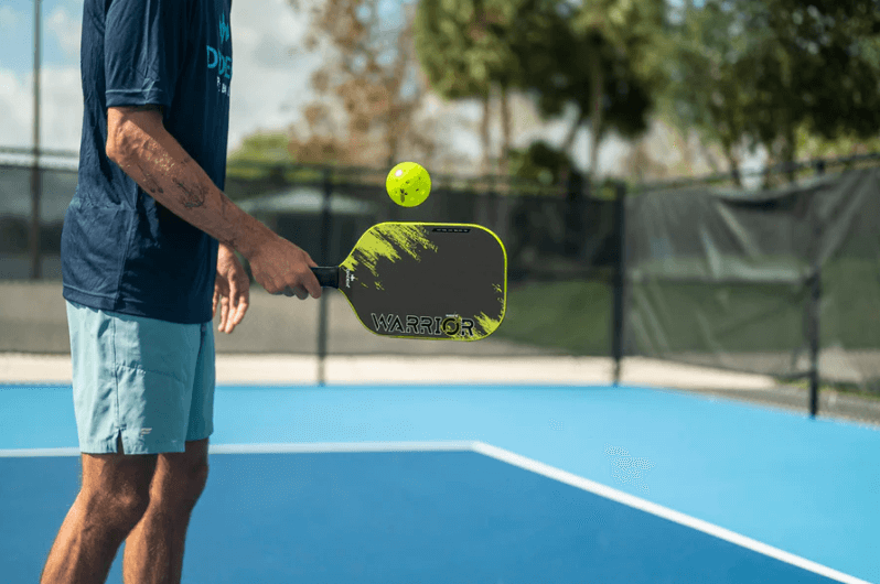 Pickleball player holding yellow diadem warrior v2 paddle
