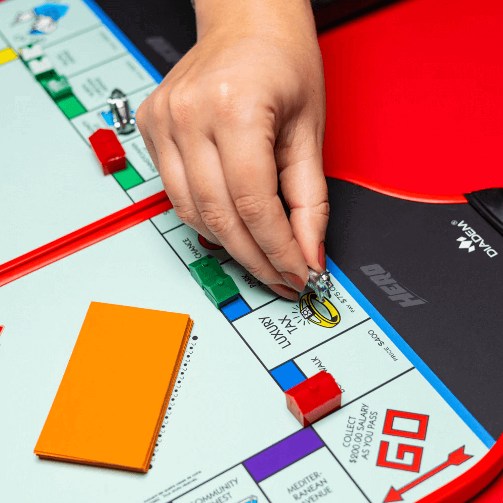 Moving monopoly piece on pickleball paddle