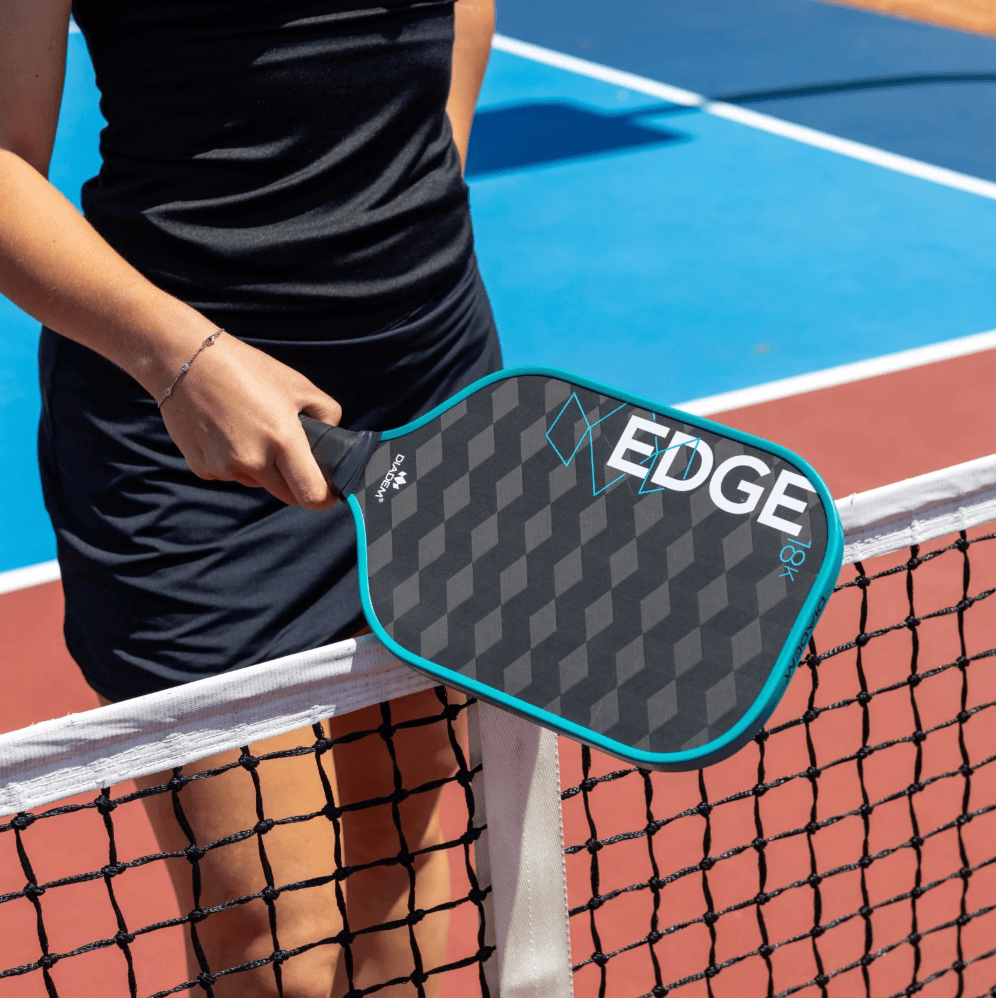 Player holding Teal Diadem Edge 18k Pickleball Paddle at net